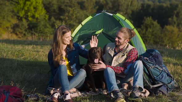 Man And Woman Traveling With Dog At Camp