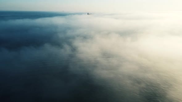 Aerial shot of  sea in foggy day with cargo ships