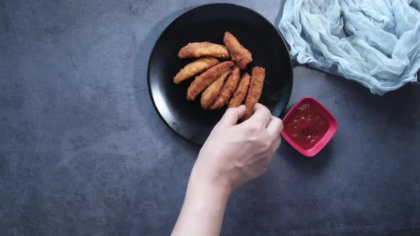 Top View of Women Hand Eating Potato Wedges.