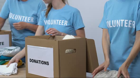 Group of Volunteers Packing Clothing in Boxes, Friendly Lady Smiling to Camera