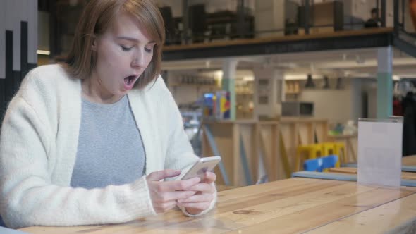 Astonished Woman Using Smartphone in Shock Wondering