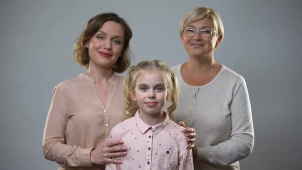 Mother and Granny Hugging Girl, Female Support and Care, Child Upbringing Family