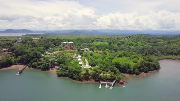 Horizontal drone shot of beautiful vacation location next to the sea in a forest with mountain and c