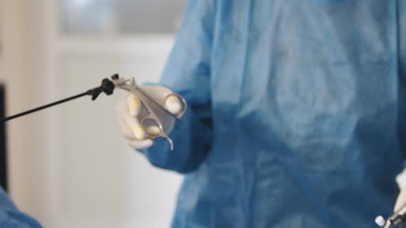 Closeup of Gloved Hands Holding Surgical Scissors