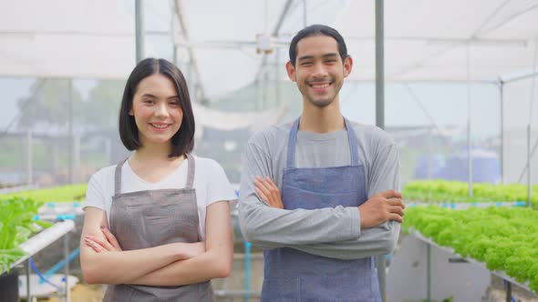 Portrait of Asian couple farmers owner working in vegetables hydroponic farm and looking at camera