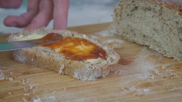 Woman spread jam on bread. 