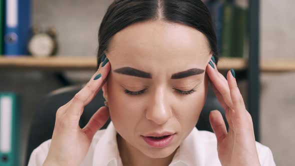 Young Female Suffers From Headache in Office Close Up