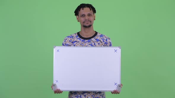 Happy Young Handsome African Man Thinking While Holding White Board