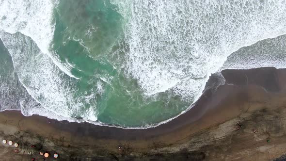 Waves breaking on Suwuk seashore beach in Kebumen, Indonesia. Aerial top down