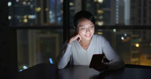 Woman read on mobile phone in the evening at home