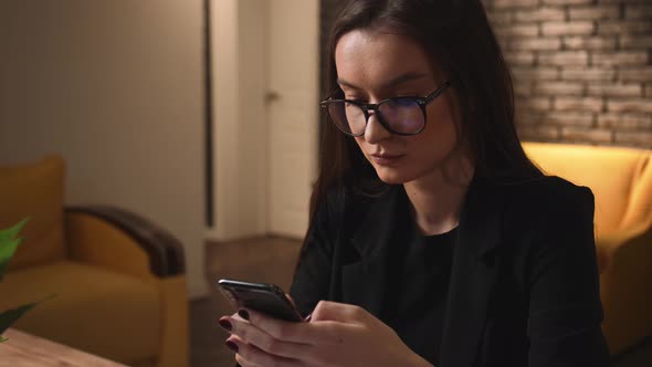 Attractive Young Woman in Glasses Using Phone for Online Shopping in Social Media Technology Mobile