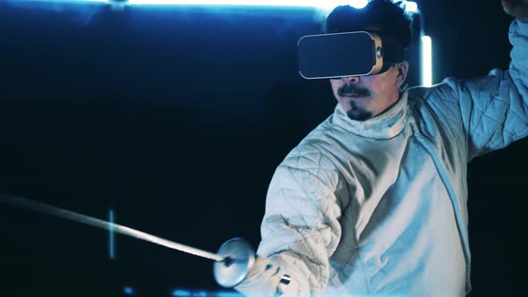 Male Athlete is Practicing Fencing Skills While Wearing a VRdevice