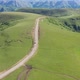 Top view of the mountain road through the green field - VideoHive Item for Sale