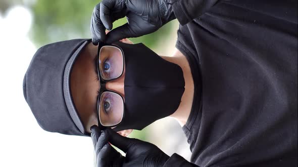 Portrait of a guy in a black medical mask and a black cap