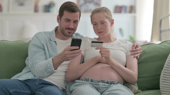 Pregnant Couple Shopping Online on Smartphone