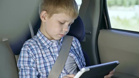 Boy Using Tablet during Car Trip