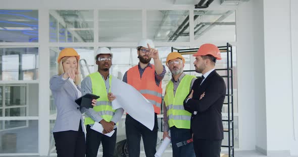 Male and Female Customers which Standing in New Built Building with Professional Engineers