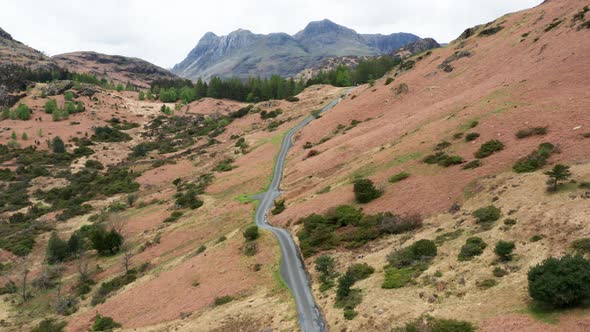 Aerial View Over Hills Towards Mountains