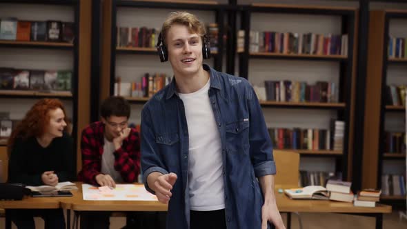 Handsome Excited European Man in Denim Shirt Performing Expressive Dance While Listening Favourite