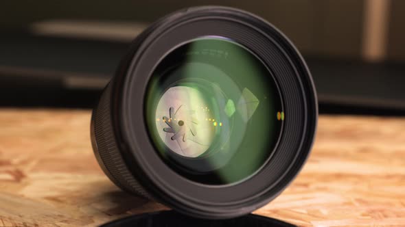 Camera Lens Showing Small Aperture With Yellow Bokeh Light On Mirror. - close up, slider right