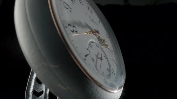Grey Antique Pocket Watch on a Stand Rotating on a Black Isolated Background