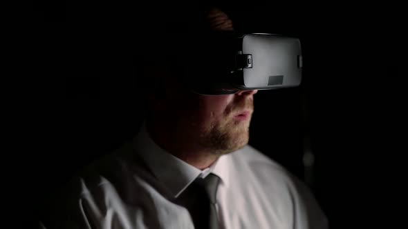 Business Man with Pleasure Playing Virtual Reality After Work in the Dark. Dive Into Another