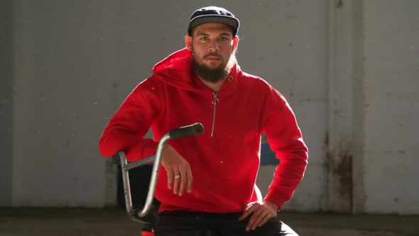 Portrait of a BMX rider in an empty warehouse