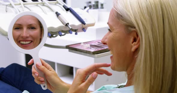 Patient checking her teeth in mirror