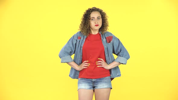 Girl Listens Carefully, Angry and Waves Her Head Negatively on Yellow Background