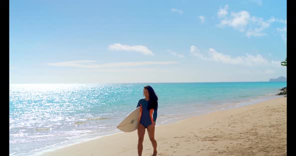 Female surfer walking with surfboard