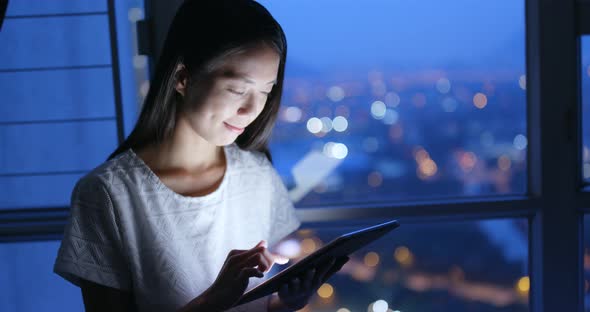 Woman use of tablet computer at night