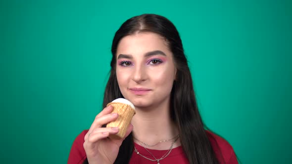 Young Happy Woman Eating Ice Cream Enjoying Sweets Isolated on Blue Background