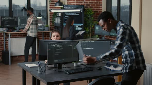 Senior Developer Coding on Laptop at Desk with Computer Screens Parsing Code