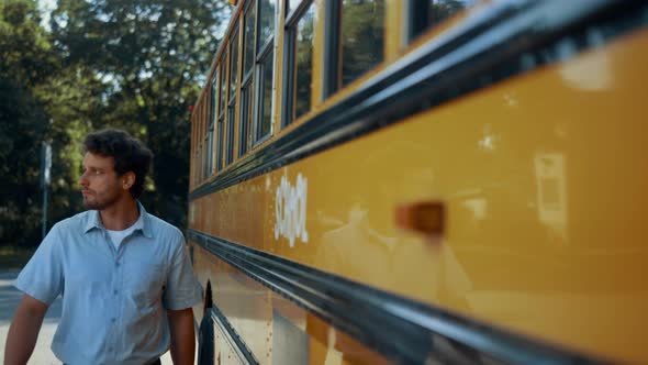 Young Schoolbus Driver Walking Along Yellow Vehicle