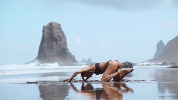 Beautiful Woman in Swimsuit Dancing While on the Beach with Black Sand Near the Ocean Canary Islands