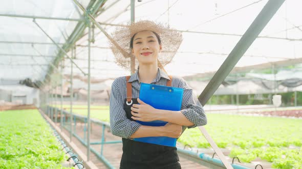 Portrait of beautiful girl farmer working in vegetable hydroponic farm.