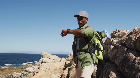 African american man hiking in countryside by the coast