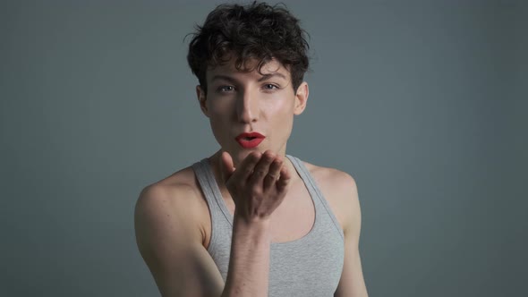 Portrait of Handsome Transgender Man with Makeup Sending Air Kiss To Camera