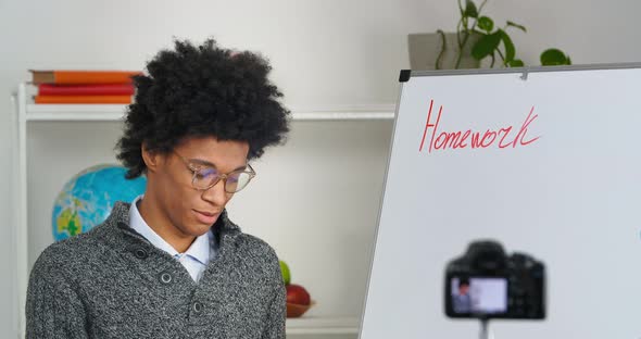 Afro American Teacher Male Tutor Stands at Blackboard Talks About Homework Writing Records Video