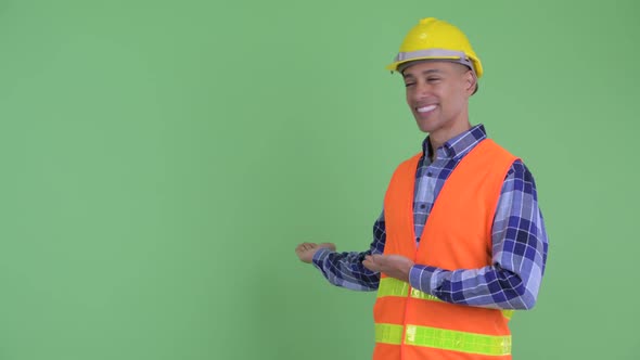 Happy Multi Ethnic Man Construction Worker Showing To Back