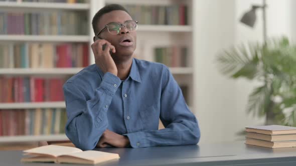 Young African Man Talking on Phone in Office