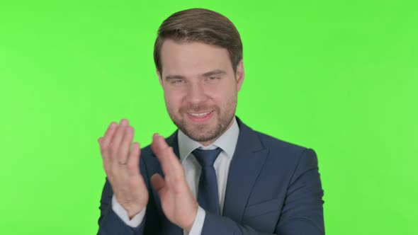 Young Businessman Clapping, Applauding on Green Background