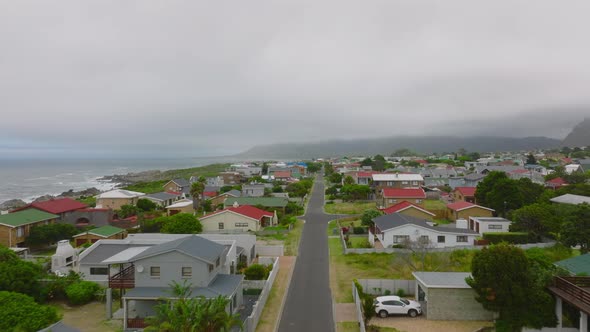 Forwards Fly Above Modern Family Houses Along Straight Street at Seaside