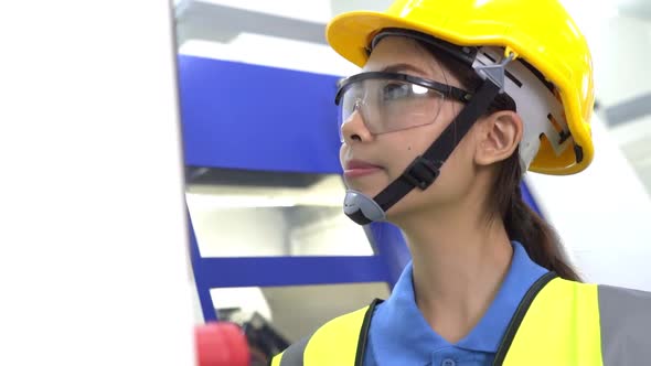 Asian worker woman operating high technology factory machine