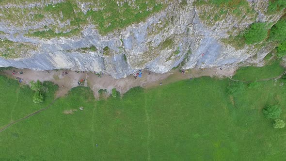 Aerial view of a man rock climbing up a mountain.