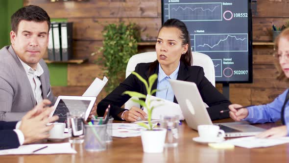 Female Team Leader Giving His Team Financial Charts