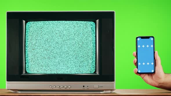 Old Television with Grey Interference Screen on Green Background and Smartphone with Blue Chroma Key