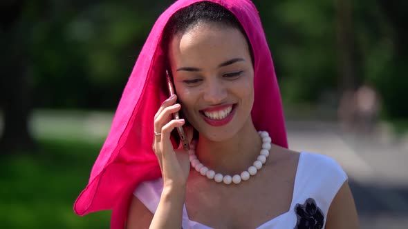 Beautiful Black Woman Is Walking Alone in Park and Chatting By Cell Phone, Ethnic Gown