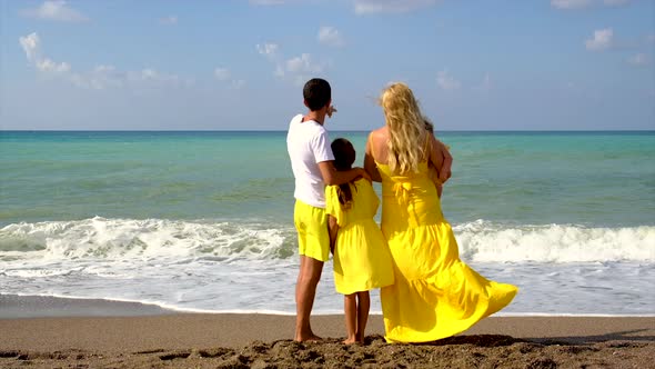 Family on the Beach Facing the Sea