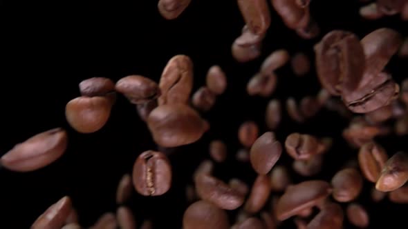 Close-up of Roasted Arabica Coffee Beans Flying Diagonally on Black Background